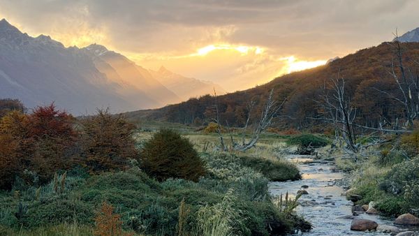sunset over mountains with stream in foreground